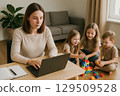 Busy mother balancing laptop work and childrens playtime indoors. 129509528