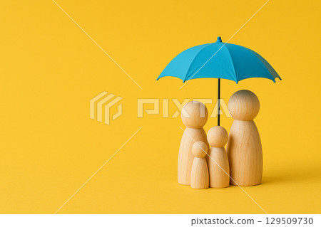 Four wooden peg figurines under a blue umbrella on yellow background symbolizing family security and insurance coverage 129509730