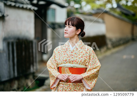A woman in a kimono strolling through the samurai residences A woman in a kimono strolling through the samurai residences 129509779