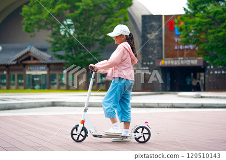 Asian girl is going to ride a scooter. Copy space Asian girl is going to ride a scooter. Copy space 129510143