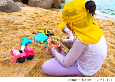 Asian girl play toys in the beach. The concept of holiday activities. 129510145
