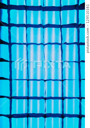 Abstract geometric background of squares. Stripbox close-up. Blue soft light. Studio lighting equipment for filming. Abstract geometric background of squares. Stripbox close-up. Blue soft light. Studio lighting equipment for filming. 129510161