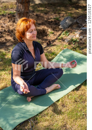 Woman meditating outdoors in a peaceful park setting during her morning routine. Mindfulness, mental balance, and emotional self-care. Woman meditating outdoors in a peaceful park setting during her morning routine. Mindfulness, mental balance, and emotional self-care. 129510327
