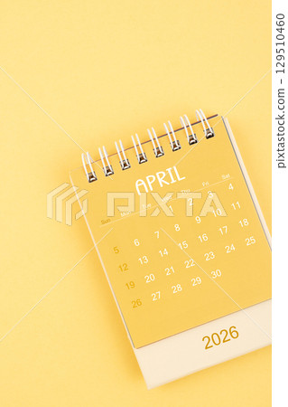 April 2026 Yellow desktop calendar on a yellow color background. 129510460
