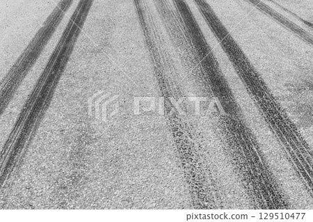 Black tire marks on road, Black rubber tire marks and tread marks, Tire trace track wheels texture and background, Auto tire tread grunge, Car wheel tyre tread track black tyre print, Aerial view. 129510477