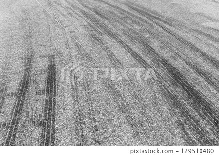 Black tire marks on road, Black rubber tire marks and tread marks, Tire trace track wheels texture and background, Auto tire tread grunge, Car wheel tyre tread track black tyre print, Aerial view. Black tire marks on road, Black rubber tire marks and tread marks, Tire trace track wheels texture and background, Auto tire tread grunge, Car wheel tyre tread track black tyre print, Aerial view. 129510480