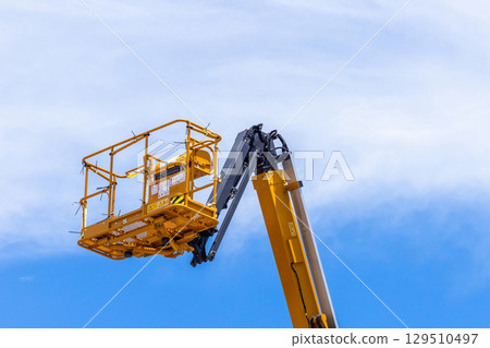 Articulate boom lift with blue sky background, Aerial platform lift telescopic boom lift hydraulic boom lift, Mobile construction crane, Construction boom lifts 129510497