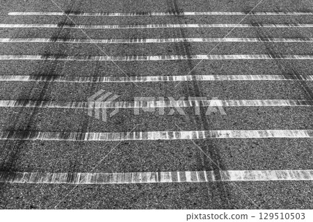 Black tire marks on road, Black rubber tire marks and tread marks, Tire trace track wheels texture and background, Auto tire tread grunge, Car wheel tyre tread track black tyre print, Aerial view. Black tire marks on road, Black rubber tire marks and tread marks, Tire trace track wheels texture and background, Auto tire tread grunge, Car wheel tyre tread track black tyre print, Aerial view. 129510503