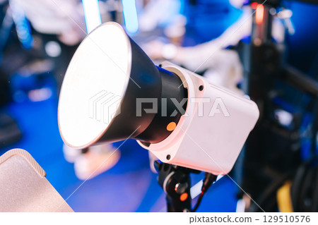 Professional studio LED spotlight close-up on a tripod. Studio lighting equipment for filming. 129510576