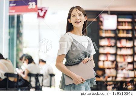 站在圖書館裡微笑的年輕女子 129510842