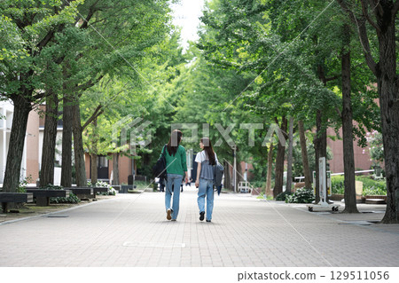 Back view of a female college student walking on campus 129511056