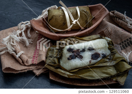 Khao tom mat, a Laotian and Thai dessert of seasoned steamed sticky rice wrapped in banana leaves normally inserted with filling made of banana and black beans for special occasions or merit making. 129511060