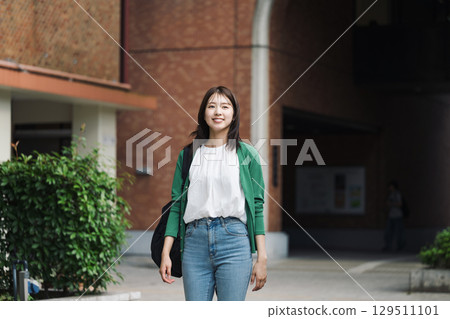 A female college student walking alone in school A female college student walking alone in school 129511101