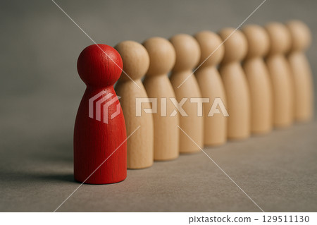 A single red figurine facing forward next to a natural figurine symbolizing partnership, rivalry, or recognition A single red figurine facing forward next to a natural figurine symbolizing partnership, rivalry, or recognition 129511130