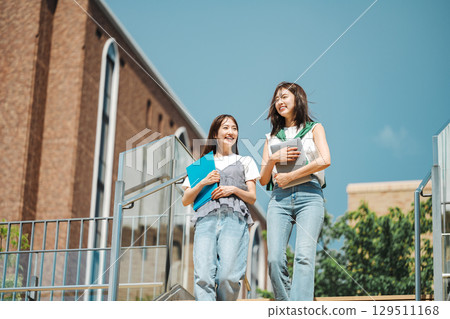 A female college student walking with friends on campus A female college student walking with friends on campus 129511168