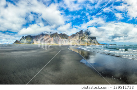 Amazing sunny day and dramatic black sand beach on Stokksnes cape in Iceland 129511738