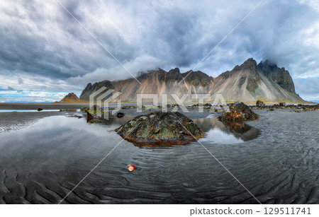 Amazing nasty day and dramatic black sand beach on Stokksnes cape in Iceland Amazing nasty day and dramatic black sand beach on Stokksnes cape in Iceland 129511741