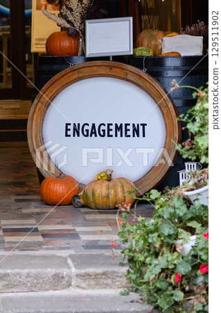 Engagement word for marketing concept. Copy space. ENGAGEMENT word written on Vibrant autumn display with colorful pumpkins and rustic decor Engagement word for marketing concept. Copy space. ENGAGEMENT word written on Vibrant autumn display with colorful pumpkins and rustic decor 129511902