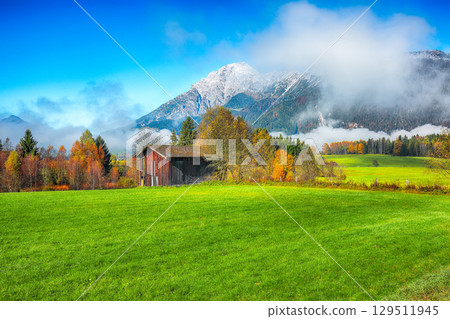 Amazing autumn view of fields and meadows in morning mist near Sell Am See. 129511945