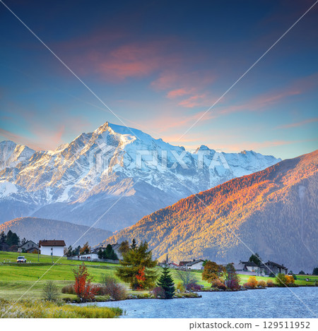 Gorgeous autumn view of Haidersee (Lago della Muta) lake with Ortler peak on background. 129511952