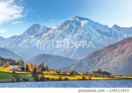 Fabulous autumn view of Haidersee (Lago della Muta) lake with Ortler peak on background. 129511953