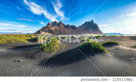 Amazing sunny day and gorgeous black sand dunes on Stokksnes cape in Iceland. Amazing sunny day and gorgeous black sand dunes on Stokksnes cape in Iceland. 129511962