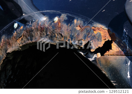 Rust damage on a vehicle wheel arch shows signs of neglect and potential repair needs 129512121