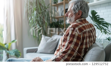 Overindulgence causes a man to lie on the sofa, suffering from painful stomach cramps and possible food poisoning. 129512732