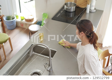 A woman cleaning the kitchen 129512799