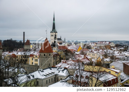 Winter panoramic view of snowy rooftops and St Olaf church in Tallinn old town Winter panoramic view of snowy rooftops and St Olaf church in Tallinn old town 129512982