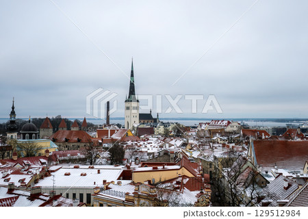 Winter panoramic view of snowy rooftops and St Olaf church in Tallinn old town Winter panoramic view of snowy rooftops and St Olaf church in Tallinn old town 129512984
