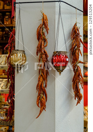 Rustic Market Display: Hanging Dried Red Peppers & Ornate Lanterns 129513204
