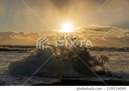 Ice blocks and spray sparkling in the sunset (Diamond Beach, Iceland) Ice blocks and spray sparkling in the sunset (Diamond Beach, Iceland) 129514094