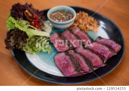 Medium rare sliced Picanha steak meat served on plate with vegetable Medium rare sliced Picanha steak meat served on plate with vegetable 129514255