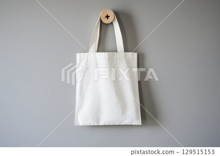 White canvas bag is hanging on a wall 129515153
