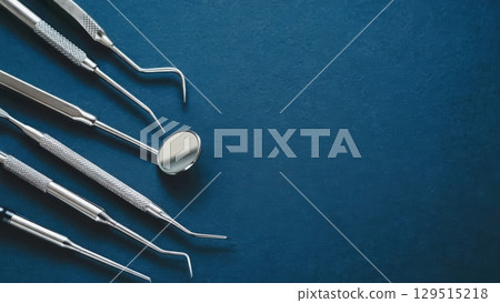 Set of dental instruments are displayed on a blue background 129515218