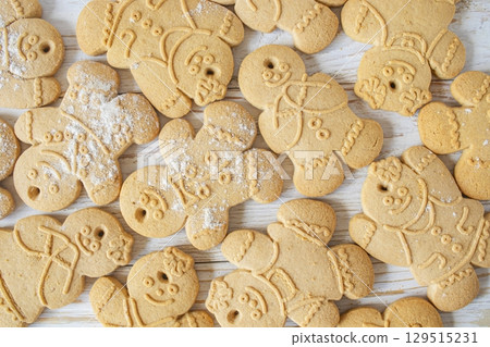 Christmas homemade gingerbread cookies on white wooden background. Top view, flat lay. Christmas homemade gingerbread cookies on white wooden background. Top view, flat lay. 129515231