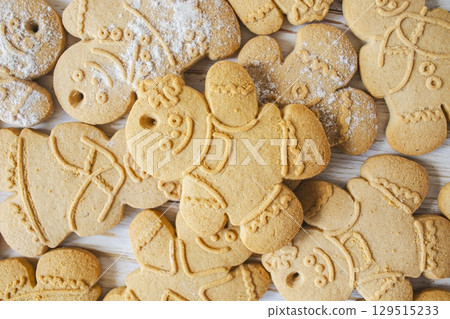 Christmas homemade gingerbread cookies on white wooden background. Top view, flat lay. Christmas homemade gingerbread cookies on white wooden background. Top view, flat lay. 129515233