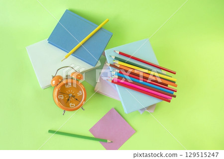 School supplies and alarm clock on green background. Back to school concept,  top view. 129515247
