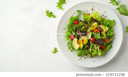 Fresh avocado and tomato salad with leafy greens served on a white plate, isolated on white background Fresh avocado and tomato salad with leafy greens served on a white plate, isolated on white background 129515296