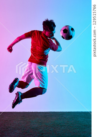 Dynamic mid-air soccer header with focused determination 129515766