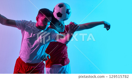 Intense soccer duel with dramatic lighting and focus Intense soccer duel with dramatic lighting and focus 129515782
