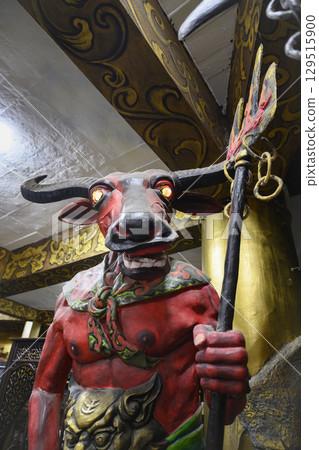 Sculpture of a demon monster with bull's head guarding the entrance to hell in the Buddhist religion 129515900
