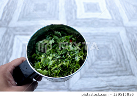 Fresh Coriander Leaves and green chilli in Mixer Jar for making spicy chutney Fresh Coriander Leaves and green chilli in Mixer Jar for making spicy chutney 129515956
