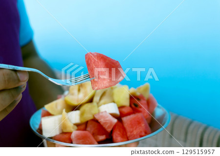 A man hand holding plate of fresh fruit salad A man hand holding plate of fresh fruit salad 129515957