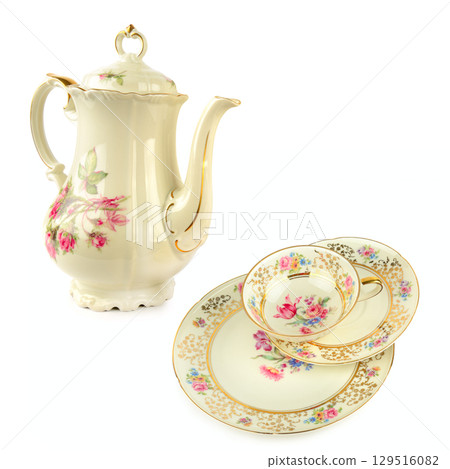 Elegant vintage porcelain coffee pot, porcelain cup and saucers isolated on white background. Free space for text. Elegant vintage porcelain coffee pot, porcelain cup and saucers isolated on white background. Free space for text. 129516082