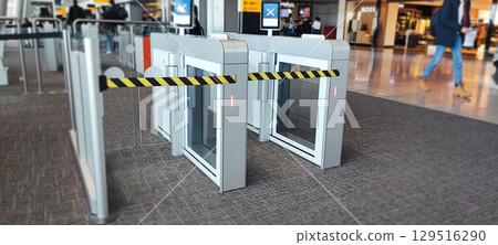 Modern airport security gate with yellow and black security barrier for passenger access control. Airport Security Gate Barrier concept 129516290