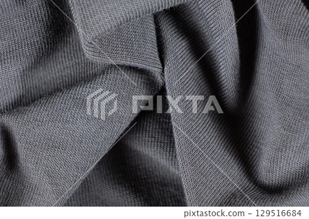 Macro texture of gray fabric consisting of cotton with a slight addition of elastane. Macro texture of gray fabric consisting of cotton with a slight addition of elastane. 129516684