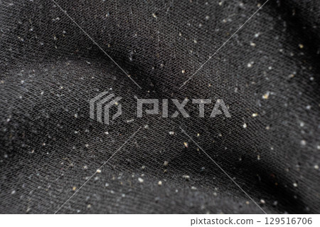 Macro texture of black fabric with lots of pilling and damage on the surface. Macro texture of black fabric with lots of pilling and damage on the surface. 129516706