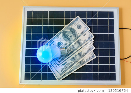 Composition with solar panel, led lamp, money  on texture background. 129516764